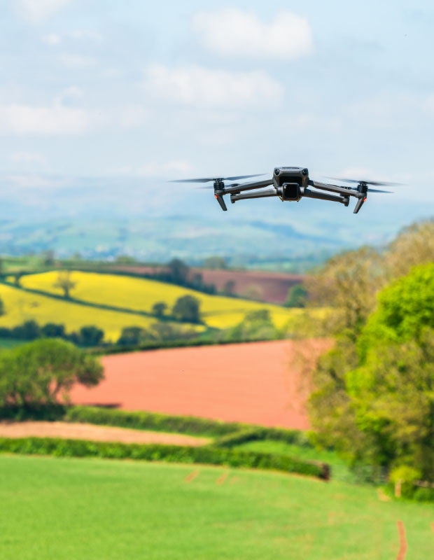 Drone en vol stationnaire pour prise de vue aérienne dans une campagne vallonée