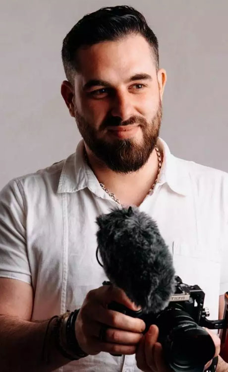 Yohann Partouche portant un appareil photo équipé d'un micro pour la prise de vue vidéo